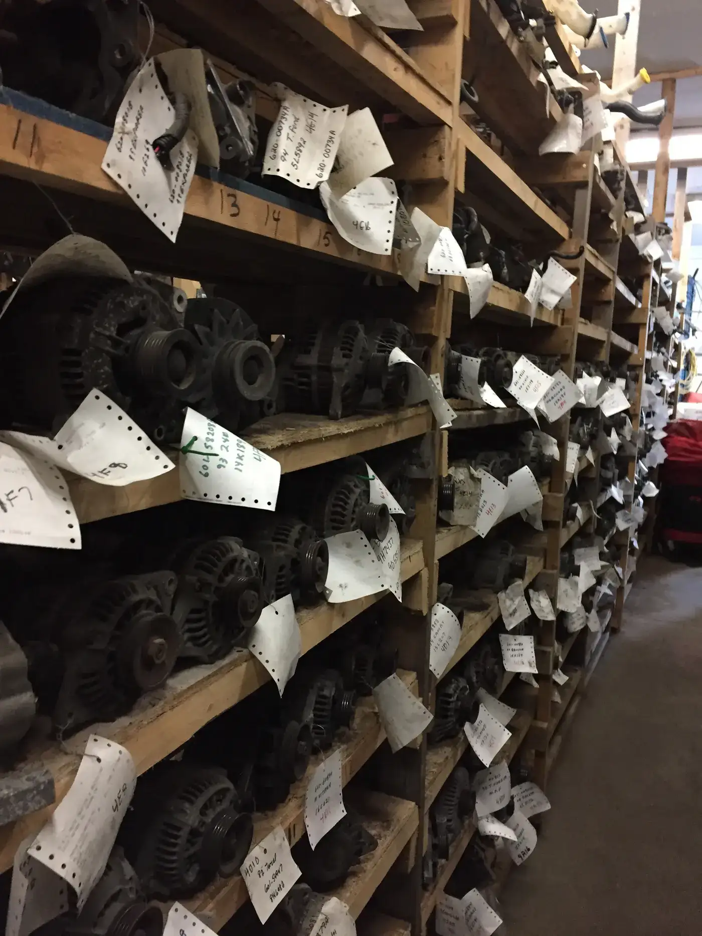 Shelves of tagged used alternators in the G&L Auto parts warehouse