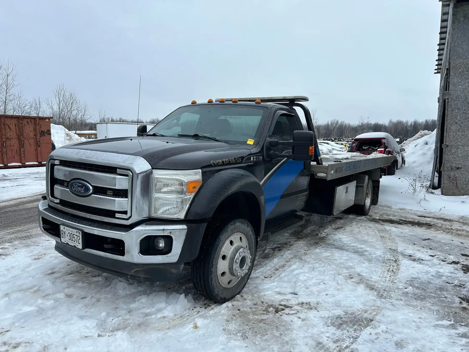 The G&L Auto flatbed tow truck outside the shop in winter